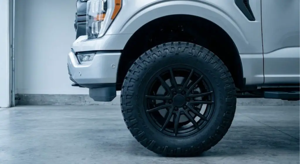 35 inch tire on a 20 inch matte black rim installed on a lifted Ford F-150 — shows correct wheel arch clearance on a 3-inch leveling kit.