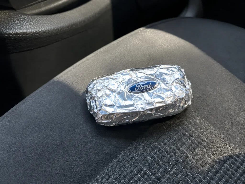 Ford key fob wrapped in aluminum foil sitting on a car seat