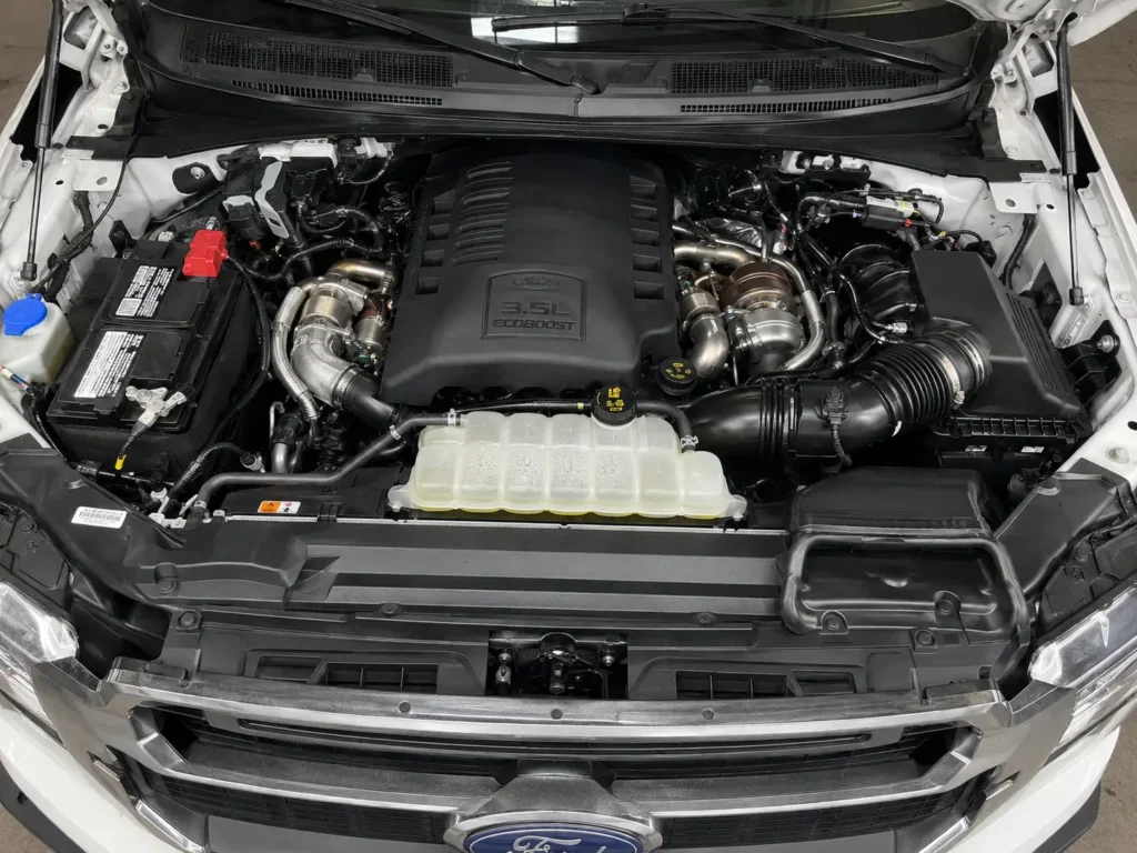 Ford F-150 Engine Options by Year Chart - 2026 3 Ford F-150 3.5L EcoBoost engine bay showing twin-turbo V6 layout by year. Ford F-150 EcoBoost engine bay, 3.5 EcoBoost engine overhead, F-150 twin turbo engine, EcoBoost V6 engine compartment, Ford truck engine closeup