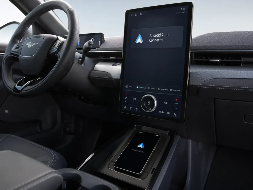 How to Enable Ford SYNC Android Auto: 2026 Complete Guide 4 Ford Mustang Mach-E interior with a smartphone resting on the wireless charging pad and the large vertical SYNC 4A screen showing an Android Auto Connected notification.