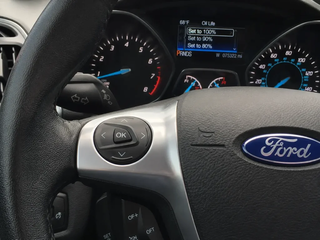 2016 Ford Escape Oil Reset — 3 Methods + Engine Oil Specs for All Engines 5 Close-up of 2016 Ford Escape steering wheel controls with directional pad and OK button, with the Oil Life settings menu visible on the instrument cluster.
