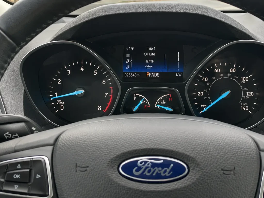 2017 Ford Escape instrument cluster showing Oil Life percentage on the center display with steering wheel controls visible.