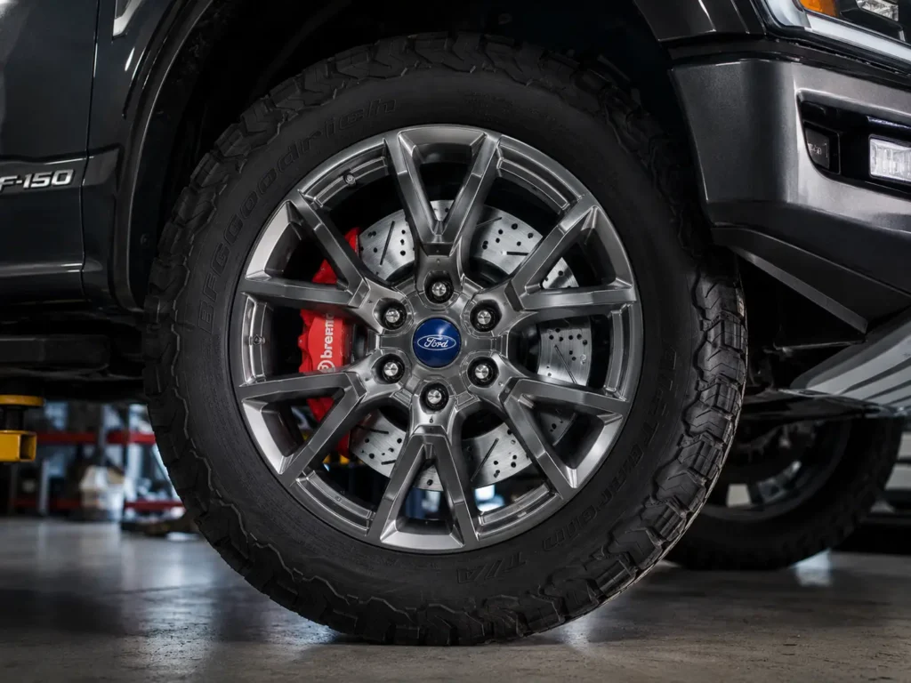 Ford F-150 brake rotor with drilled disc and red caliper