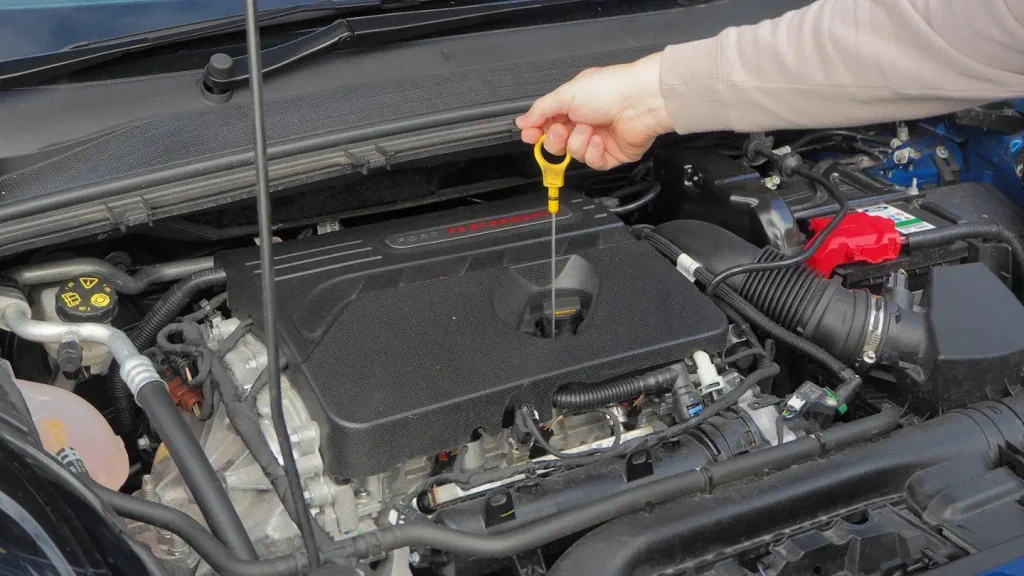 Technician checking engine oil level with dipstick on Ford Bronco Sport 2.0 EcoBoost.