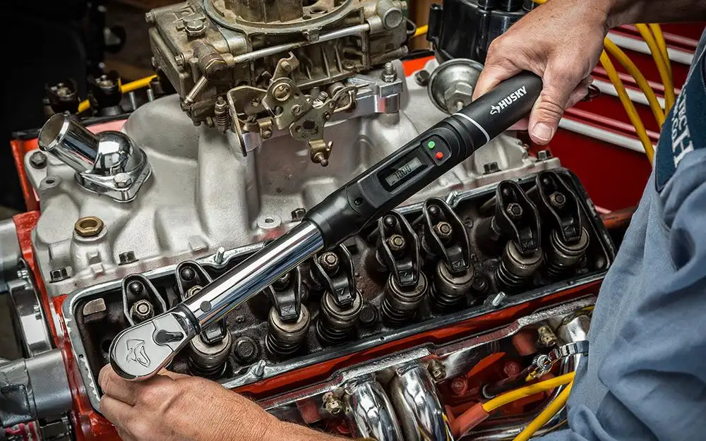 Mechanic tightening Ford 289 cylinder head bolts using a calibrated torque wrench
